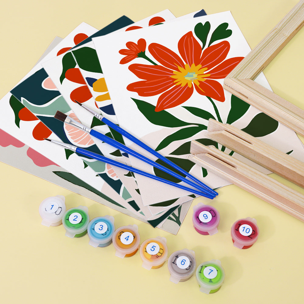 Colorful floral designs on paper with paintbrushes and paint containers on a yellow background. Mini Bloom Garden 6 pack Paint by numbers