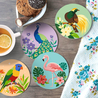 Five round coasters with colorful tropical and animal illustrations are arranged on a wooden tabletop with a cup of tea, cookies, and a floral napkin. Bird Garden Coasters - 6 Pack Paint by Numbers Lifestyle