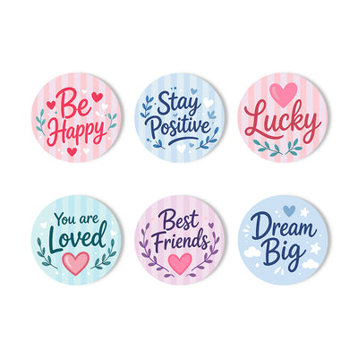 Six round decorative stickers with pastel striped backgrounds and positive phrases including 'Be Happy,' 'Stay Positive,' 'Lucky,' 'You are Loved,' 'Best Friends,' and 'Dream Big,' arranged on a white background. Inspiring Words Coasters - 6 Pack Paint by Numbers