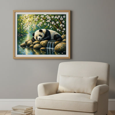 Framed painting of a panda by a stream on a wall above a beige armchair.
