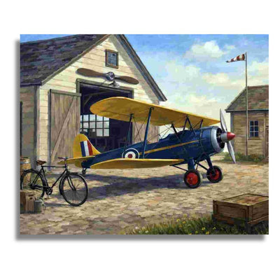 A vintage-style painting of a blue and yellow biplane parked in front of a wooden garage, with a bicycle, stone ground, and another building in the background. Vintage Airplane - Paint by numbers