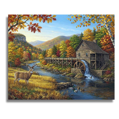 A square canvas wall art print depicting a scenic autumn landscape with a deer by a river, a wooden watermill with a wheel, colorful fall foliage, and mountains in the background. The canvas is shown against a plain white background with a subtle drop shadow. Water Mill - Paint by numbers